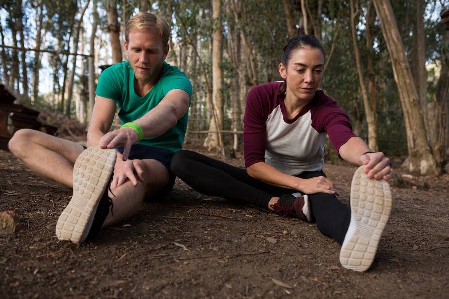 Woman Performing Stretching Exercise With The Help